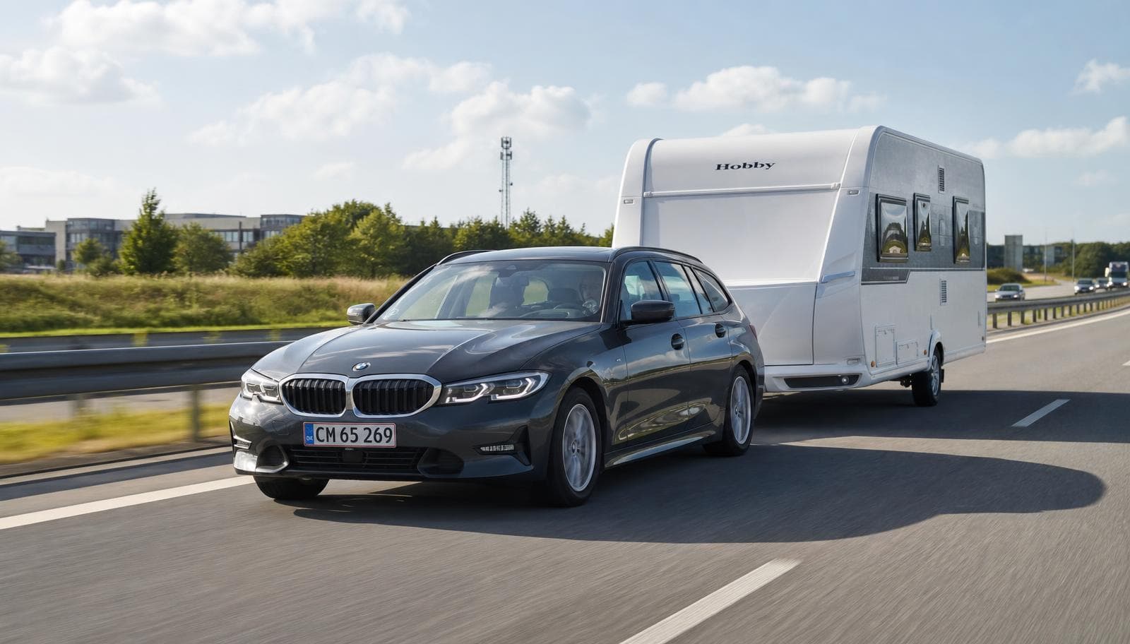 Dieseldrevet stationcar trækker campingvogn på dansk motorvej